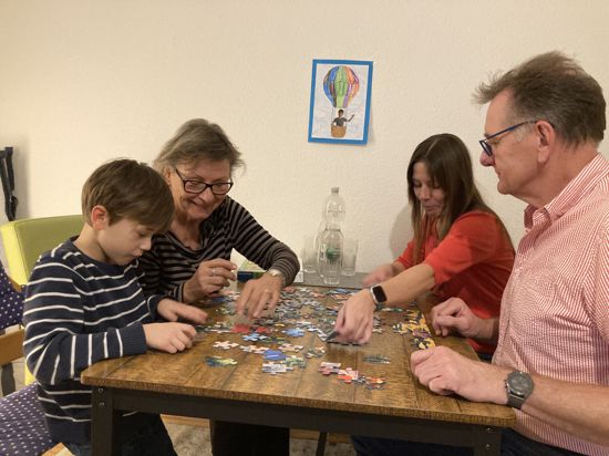eine Familie beim Puzzlen