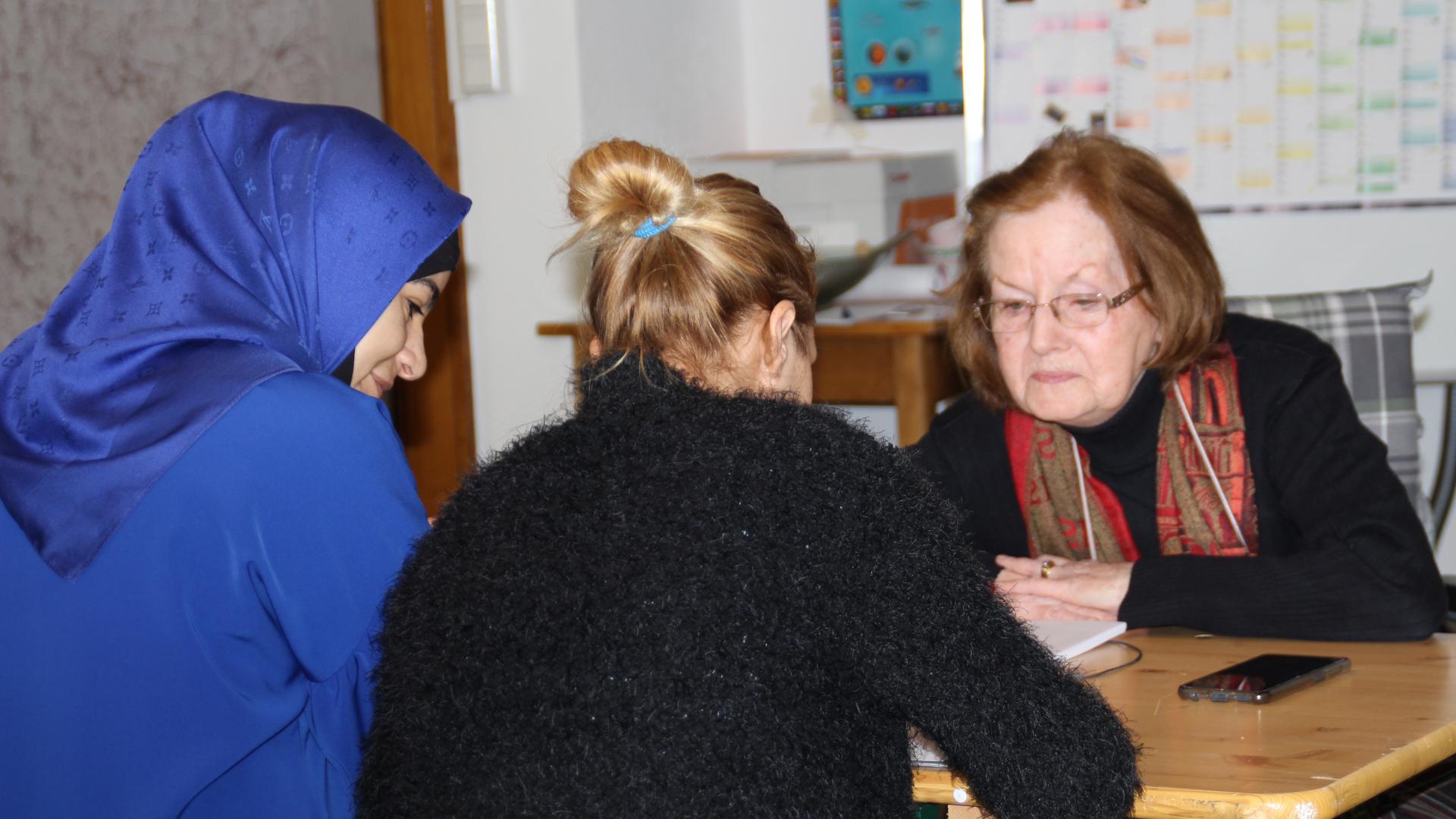 Deutschunterrichts mit zwei Frauen und Kursleiterin Ingrid Chaventré (rechts)