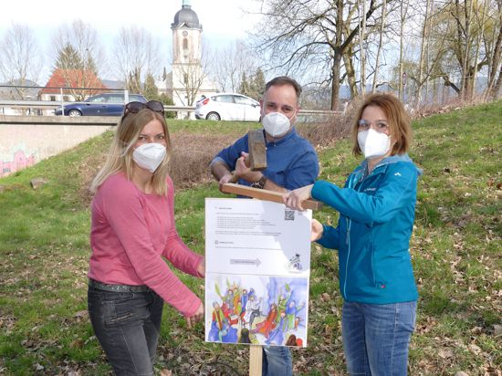 Helfer bringen Hinweisschilder für den Osterweg in Gaggenau an