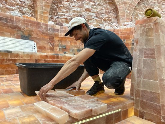 ein Handwerker bearbeitet in der Salzwelt des Thermalbads Rotherma Salzblöcke