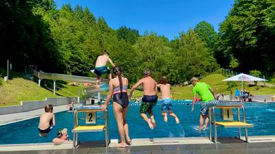 Kinder springen vom Beckenrand im Schwimmbad Sulzbach.