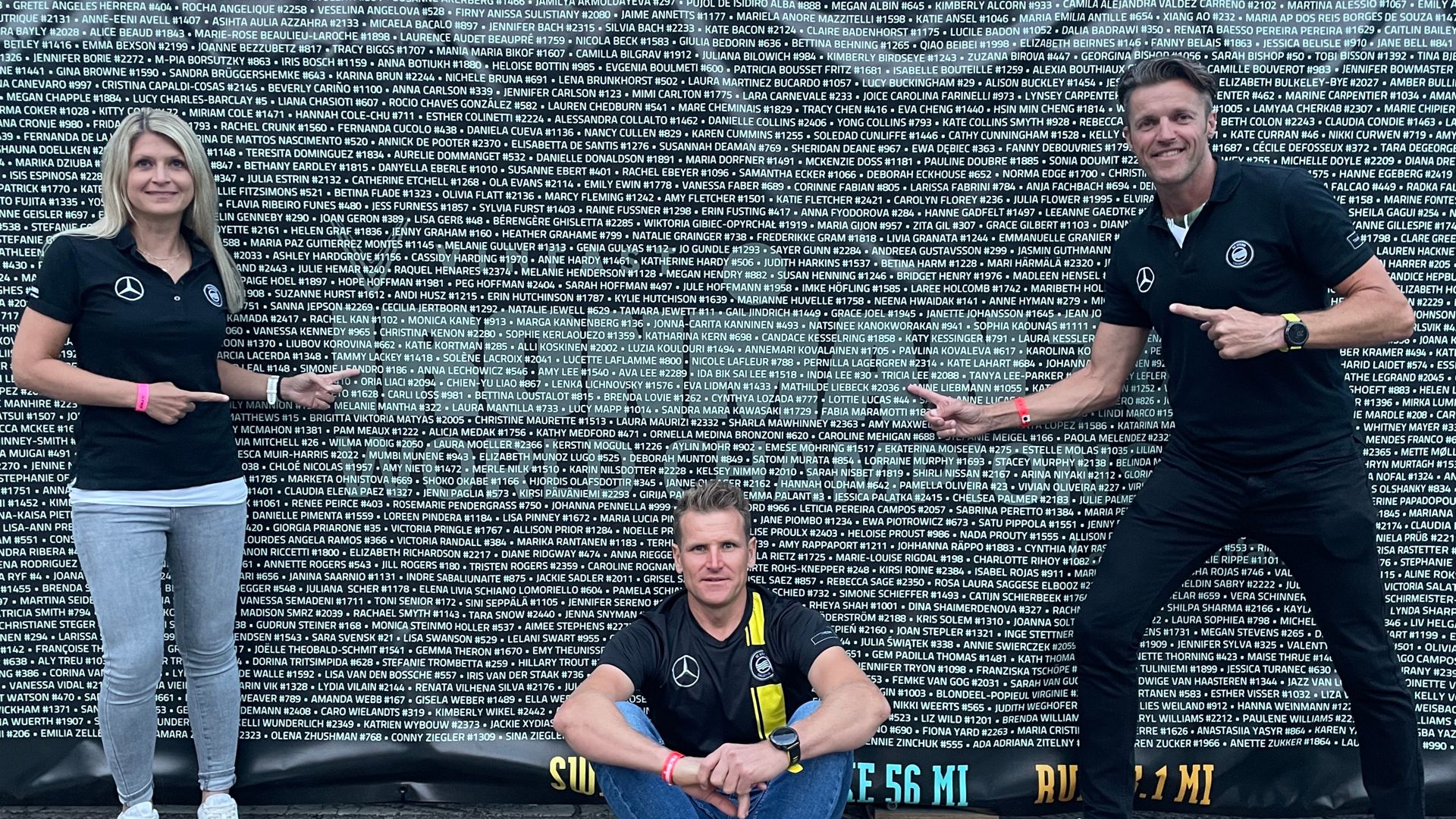 Isabel Striebig und Kai Schröder (rechts) deuten auf ihre Namen an der Wand, die die rund 6.000 Teilnehmer bei der Halb-Triathlon-WM verewigt. Hermann Weil (sitzend) war in Finnland der dritte Qualifikant von der SG Stern Gaggenau.