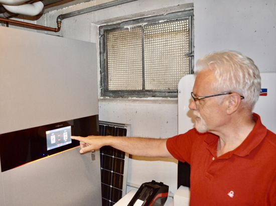 Norbert Gerstner zeigt im Keller auf sein Blockheizkraftwerk 