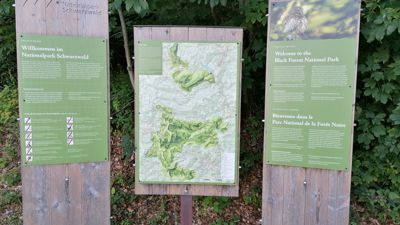 Schilder: Willkommen im Nationalpark Schwarzwald auf Deutsch, Französisch und Englisch.