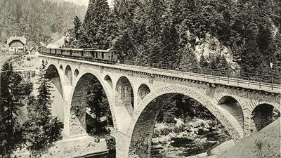 Ein Zug fährt über eine große Brücke.