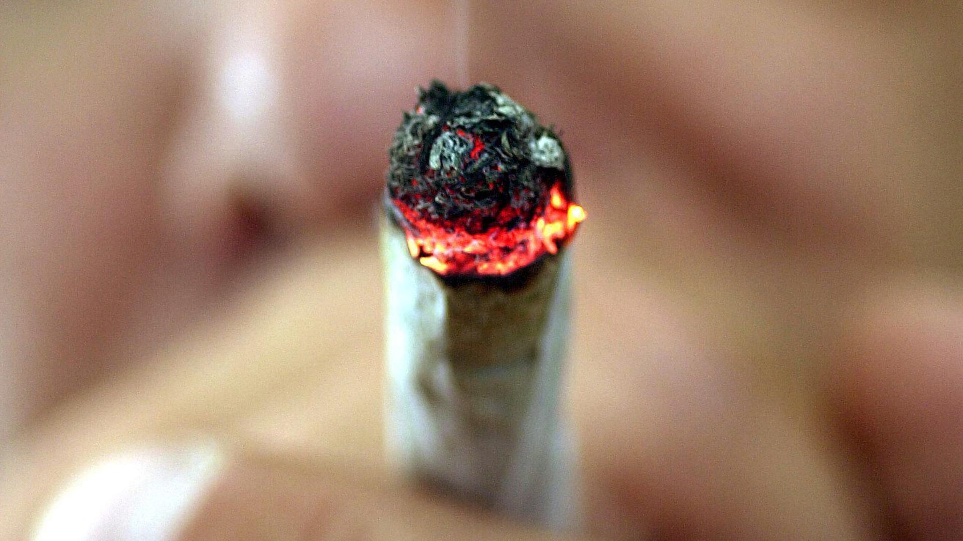 Ein Mann raucht einen Joint.