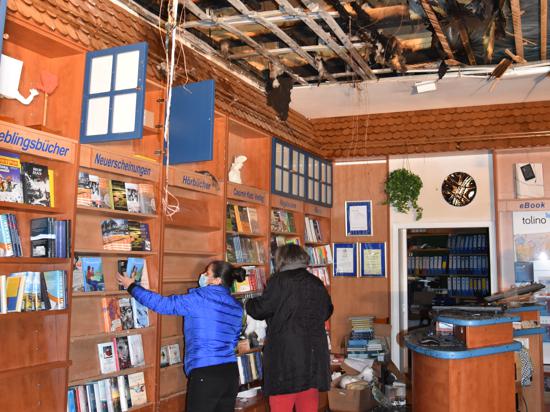 In der Bücherstube in Gernsbach räumen nach dem Brand zwei Frauen die Bücher aus den Regalen 