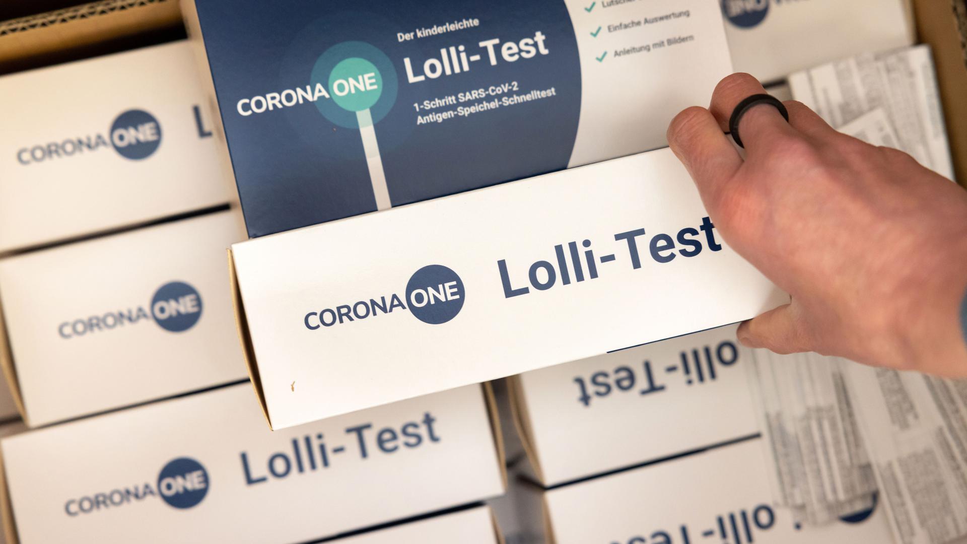 Eine Schulleiterin packt die Corona-Selbsttests "Lolli-Test" für die Grundschüler zum Nachweis von SARS-CoV-2-Erregern aus.