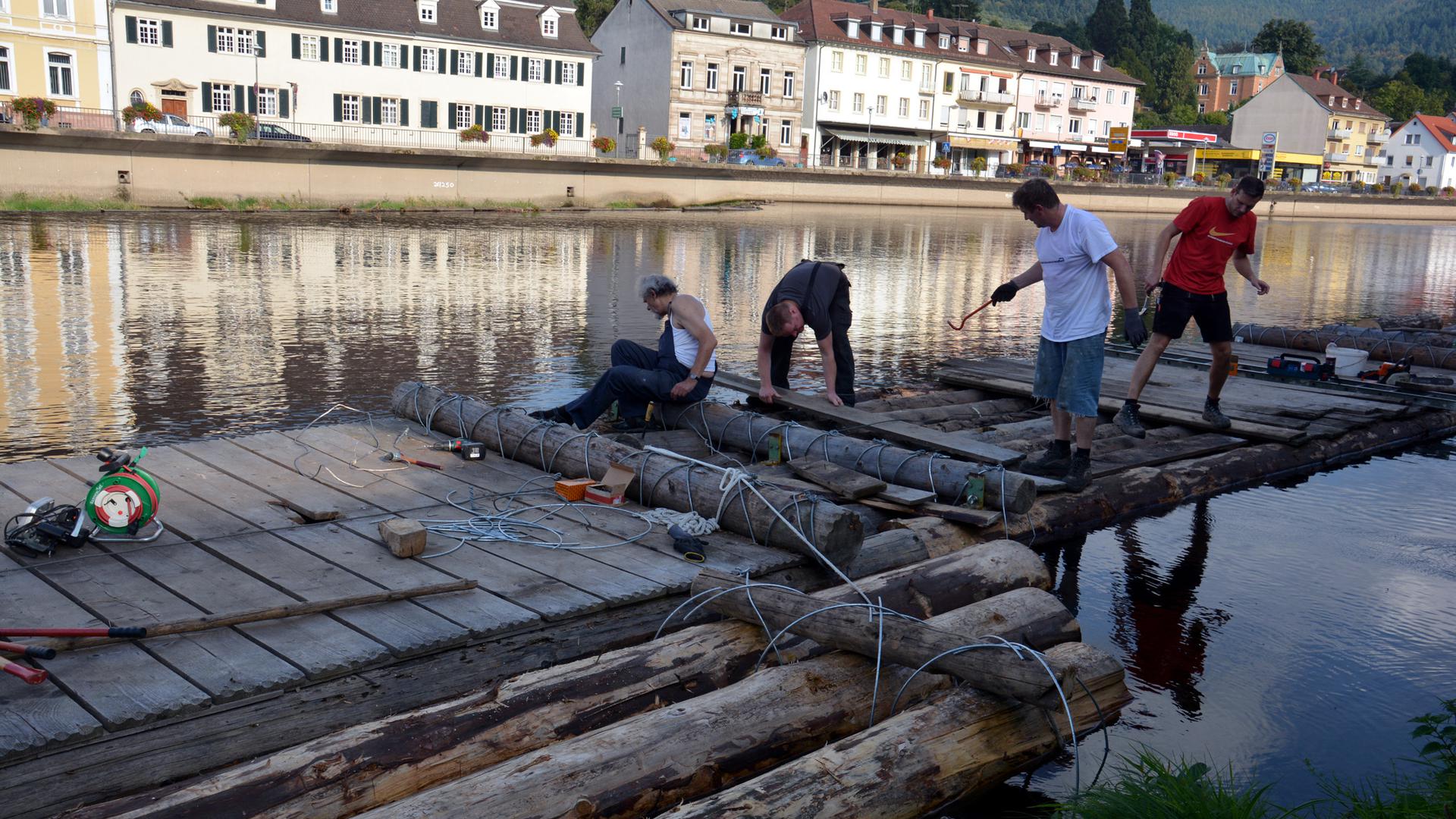 Vier Männer arbeiten an einem Floß auf der Murg in Gernsbach 