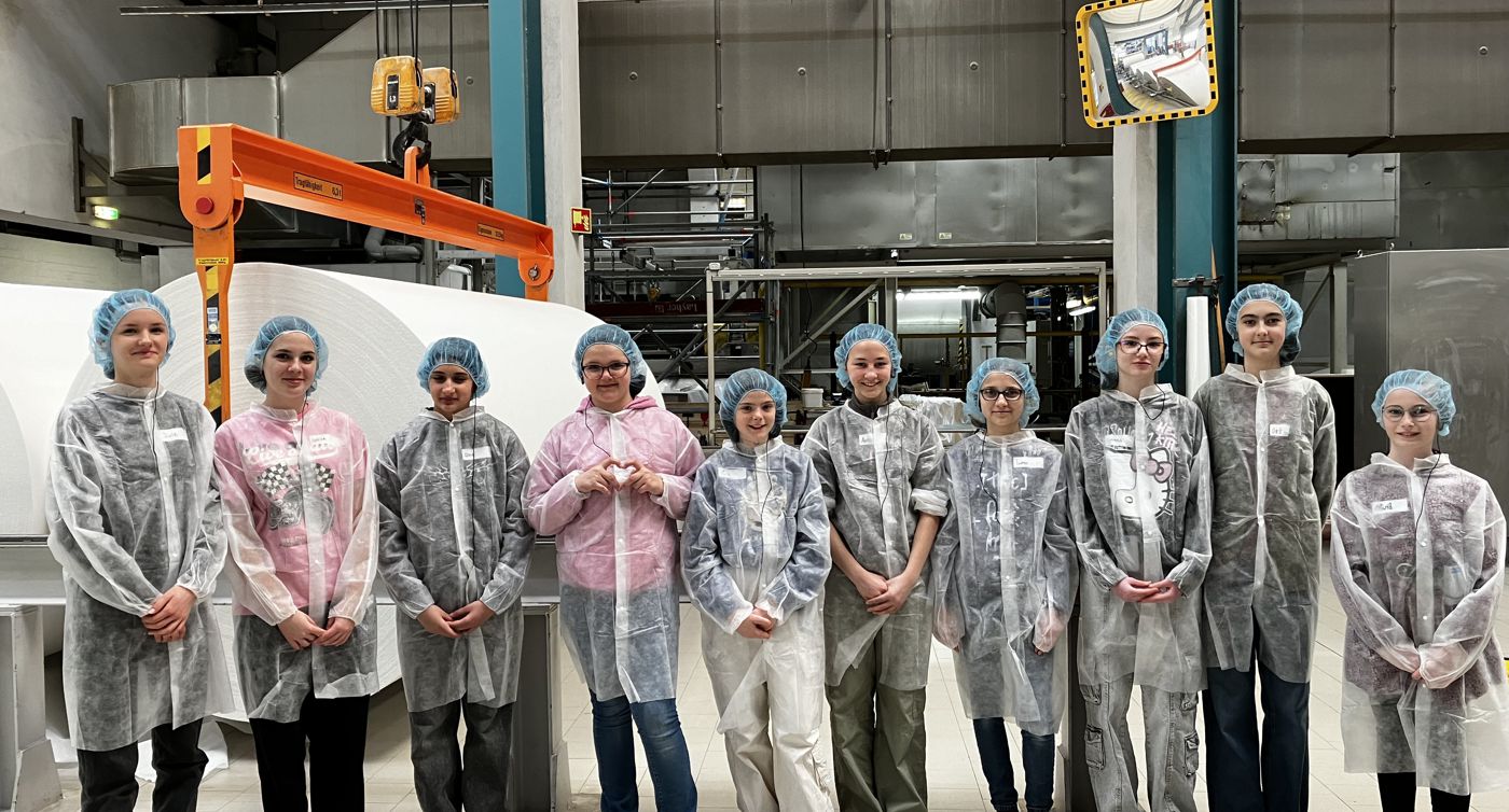 10 teilnehmerinnen stehen im Werk von der Papierfabrik Glatfelter.