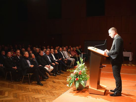 Bürgermeister Julian Christ hält eine Rede in einer Halle. 