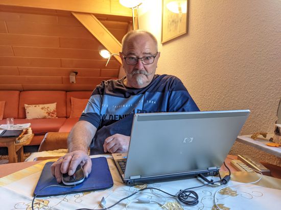 Ein Mann sitzt vor seinem Laptop.