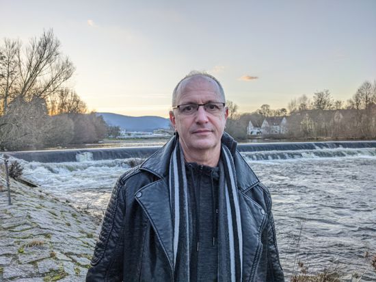 Ein Mann steht vor einem Fluss.