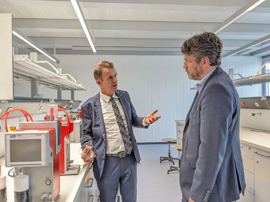 Zwei Männer stehen in einem Unterrichtsraum der Papiermacherschule Gernsbach. 