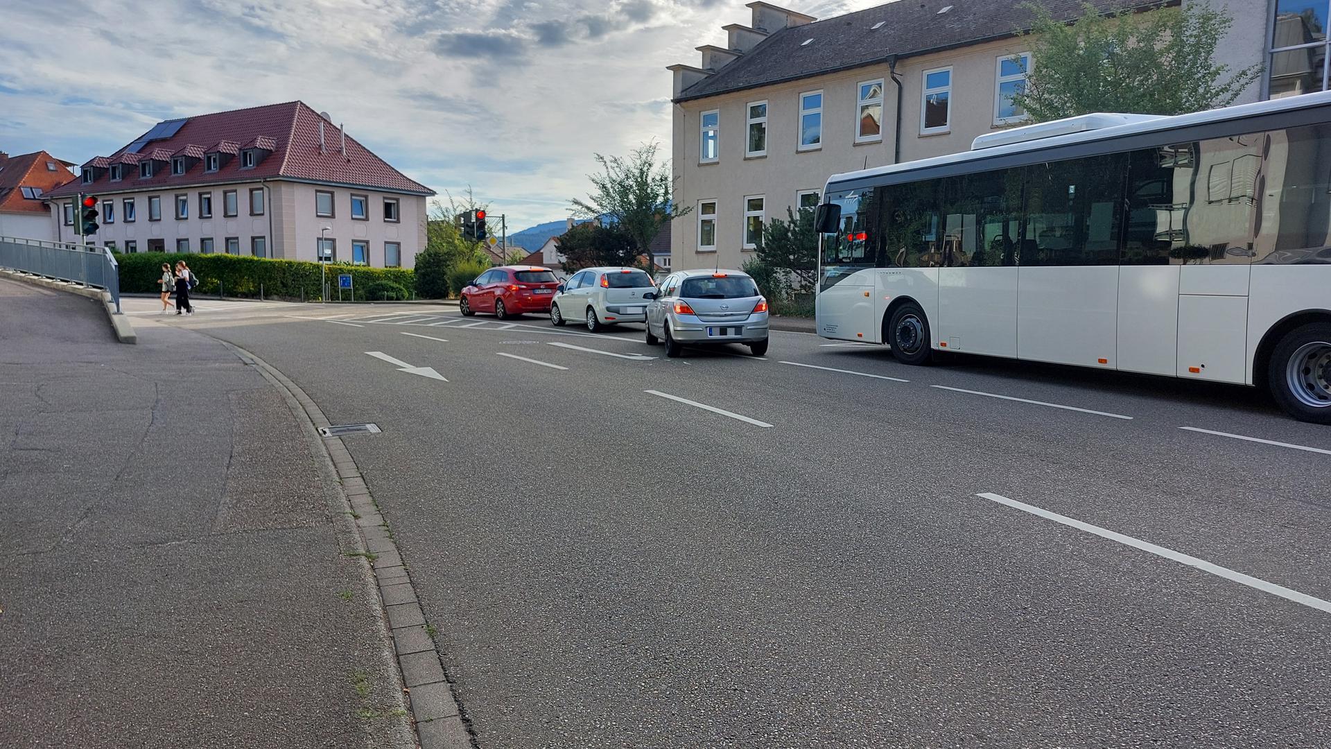 Ein Bus und mehrere Autos warten an einer Ampel.