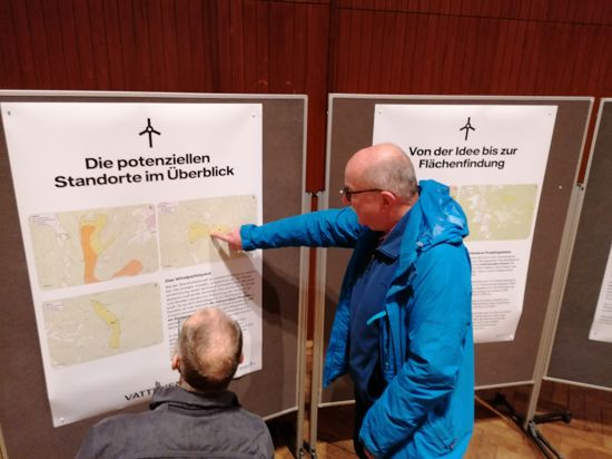 Zwei Männer informieren sich vor einer Infotafel über die potenziellen Windkraftstandorte in Gernsbach.
