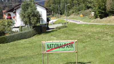 Ein Schild mit der durchgestrichenen Aufschrift Nationalpark am Ortseingang von Hundsbach.