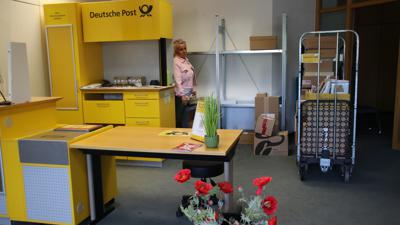 Claudia Simon steht zwischen Paketen und hinter dem Tresen der Post-Filiale in Loffenau