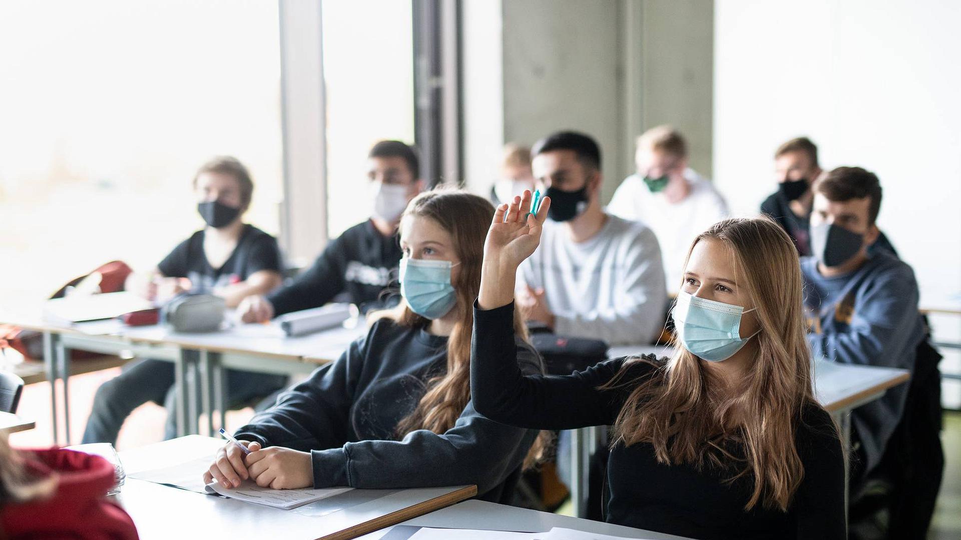 Schüler büffeln an einem Gymnasium mit Maske.
