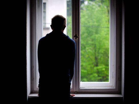 Ein Mann steht allein an einem Fenster und schaut nach draußen.

a Man is alone to a Window and looks after outside