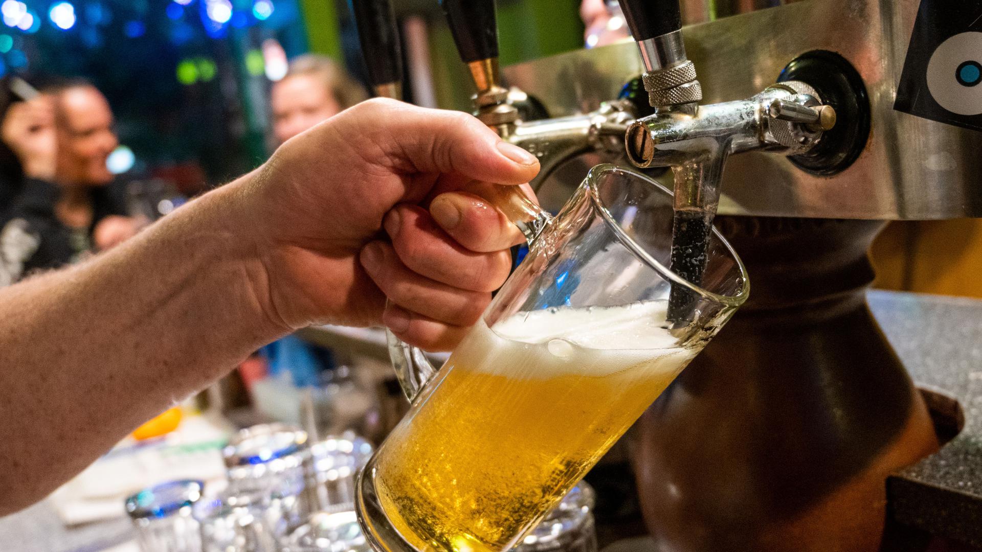 In einer Bar wird ein Bier gezapft.