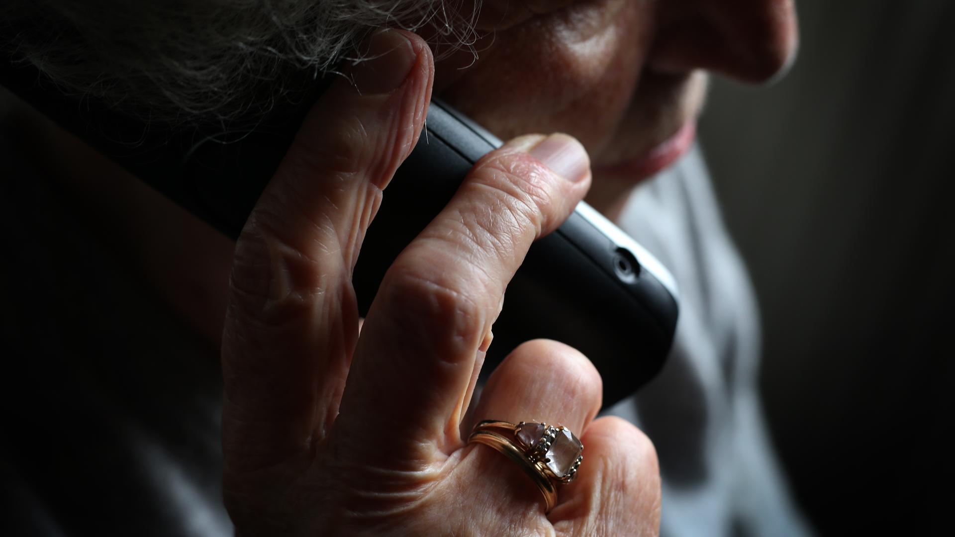 Eine ältere Frau telefoniert mit einem schnurlosen Festnetztelefon. 