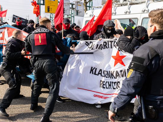 Polizisten schlagen mit Schlagstöcken auf Demonstranten ein, um den Demonstrationszug gegen den Landesparteitag der AfD Baden-Württemberg zu stoppen. 