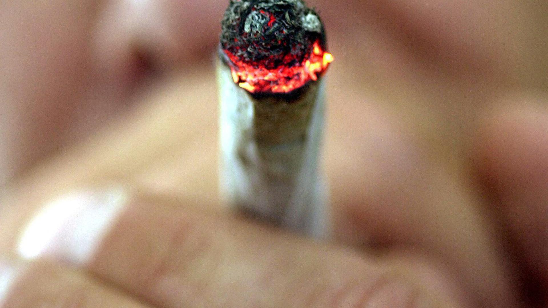 Ein Mann raucht einen Joint. 