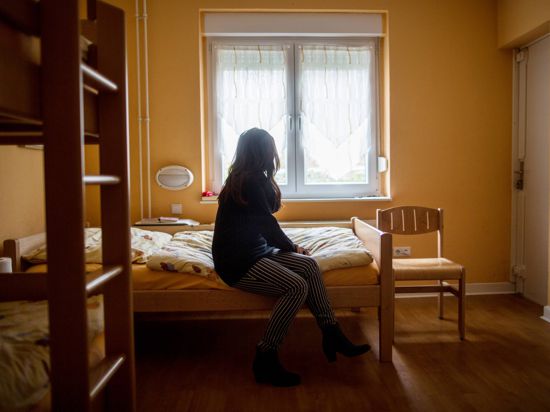 Eine Frau sitzt am 12.11.2015 im Frauenhaus in Herne (Nordrhein-Westfalen) auf einem Bett. Foto: Maja Hitij/dpa (zu lnw-KORR vom 23.11.2015) +++(c) dpa - Bildfunk+++ | Verwendung weltweit