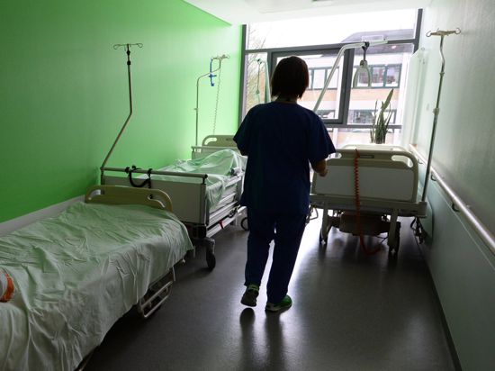 ARCHIV - Eine Krankenschwester geht am 21.03.2014 in einem Krankenhaus über einen Flur und holt ein Bett. Foto: Patrick Seeger/dpa (zu dpa «Kliniken und Krankenkassen streiten über Krankenhausreform» vom 26.05.2014) +++(c) dpa - Bildfunk+++ | Verwendung weltweit