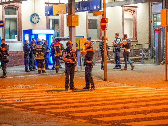 Schwerbewaffnete Polizisten sichern nach einer Drohung am Dienstagabend den Bahnhof in Offenburg.