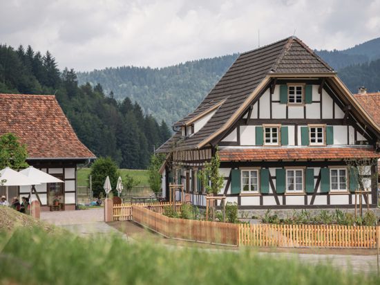 Ein Fachwerkhaus vor Schwarzwaldkulisse. Der Blick geht auf die Giebelseite