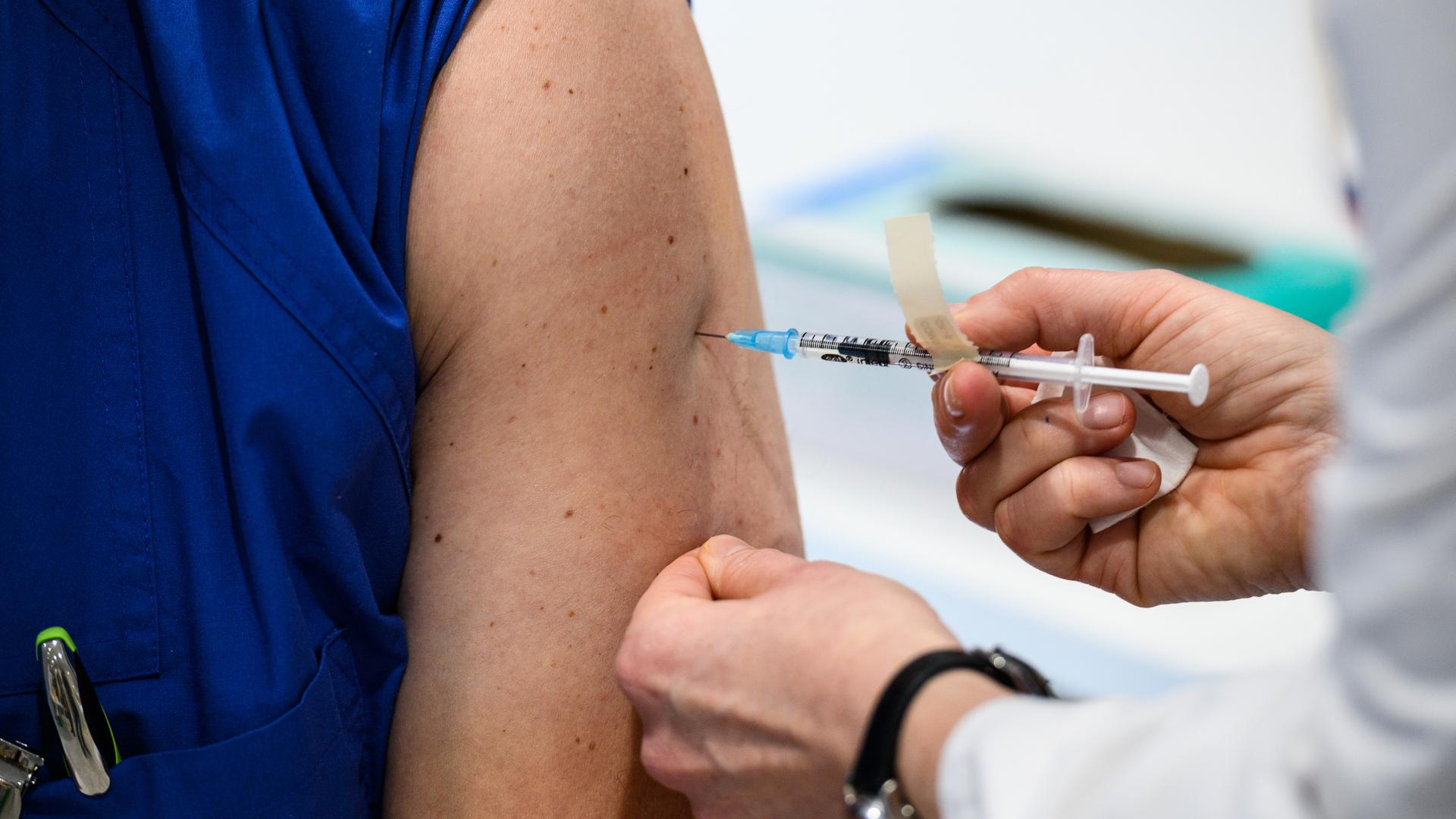 Eine Pflegekraft erhält eine Covid-Impfung. 