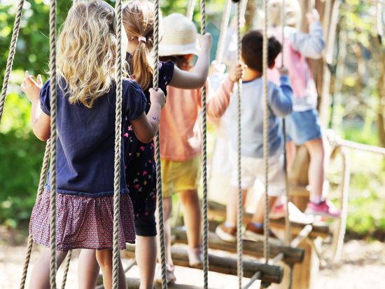 Kinder laufen in der Kindertagesstätte, Kita Morgenland, über eine Hängebrücke. Die Kindertagesbetreuung in Nordrhein-Westfalen kehrt zurück in den Regelbetrieb. +++ dpa-Bildfunk +++