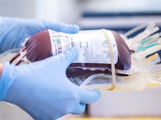 Eine Mitarbeiterin des Blutspendezentrums des Deutschen Roten Kreuzes hält eine Blutkonserve in den Händen. Spenderblut ist auch in der Corona-Pandemie wichtig. Darauf will NRW-Gesundheitsminister Laumann mit Vertretern des Deutschen Roten Kreuzes (DRK) und der Uniklinik aufmerksam machen. +++ dpa-Bildfunk +++