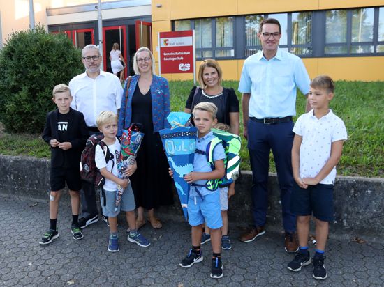 Die Familien Bürck und Würthner stehen mit den Erstklässlern Max und Julian vor der Gemeinschaftsschule in Achern. Die Kinder halten Schultüten in der Hand.