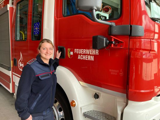 Eileen Ganther steht neben einem Einsatzwagen der Feuerwehr Achern.