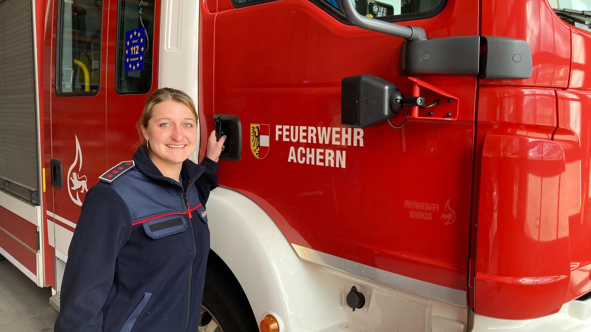 Eileen Ganther steht neben einem Einsatzwagen der Feuerwehr Achern.