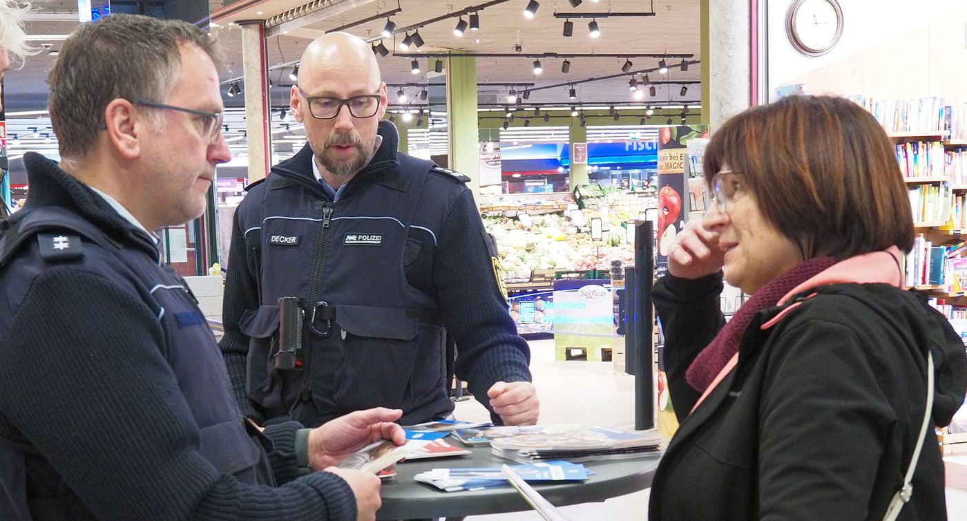 Zwei Polizisten sprechen im Einkaufsmarkt mit einer Kundin