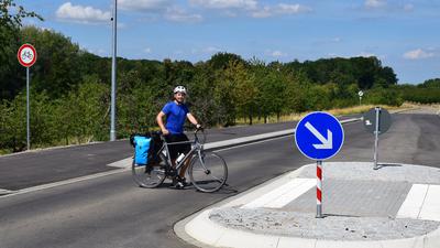 Ein Radfahrer wechselt die Straßenseite, weil auf dem Radweg ein Verbotsschild steht.