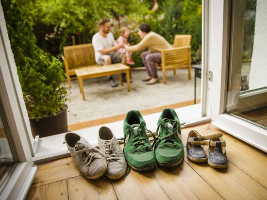 Blick auf eine Terasse mit Familie und Schuhen iin verschiedenen Größen.