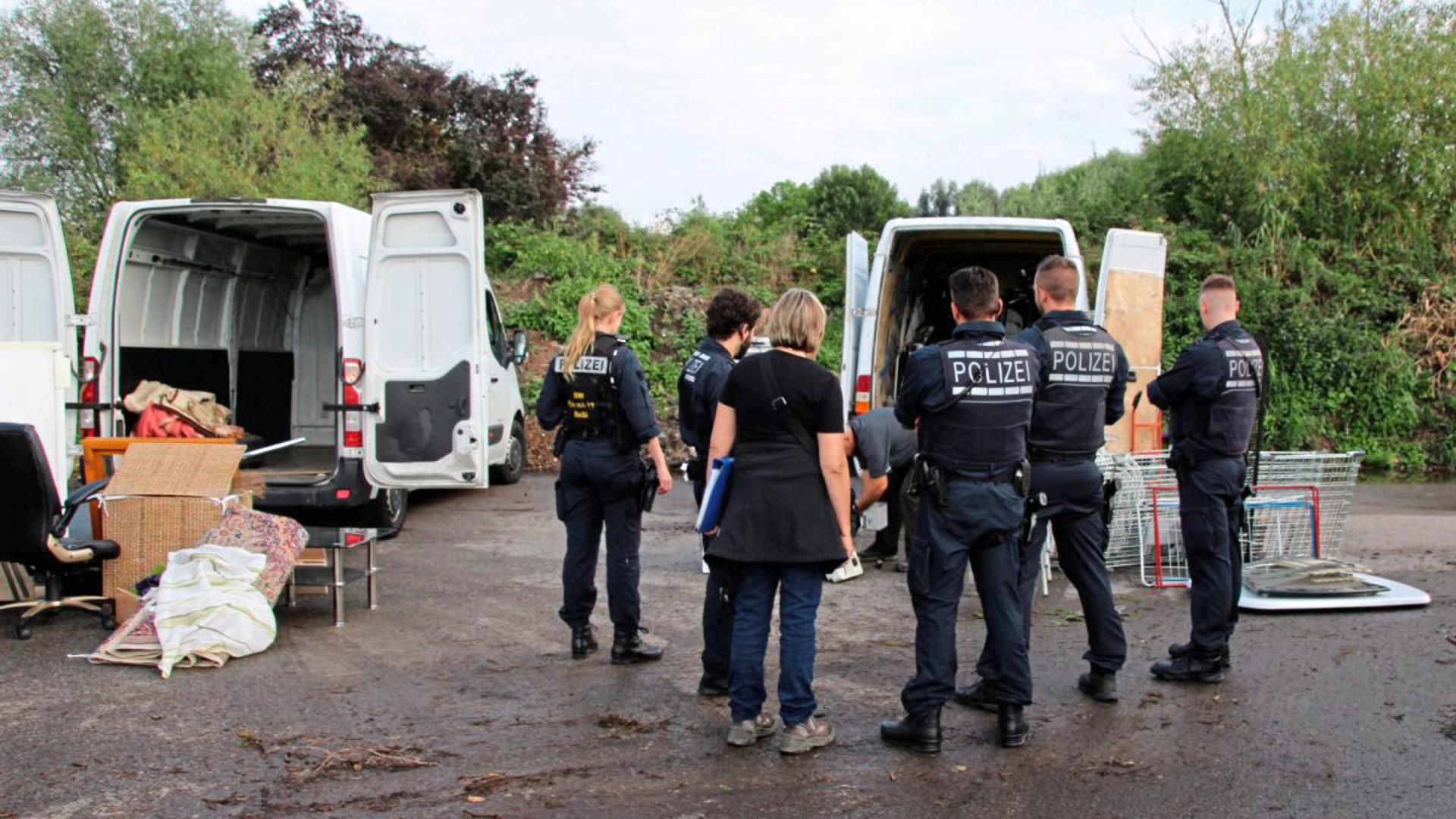 Polizisten und Sperrmüllsammler mit weißen Kleinlastwagen