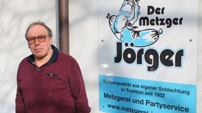 Wilfried Jörger vor dem Schild seines Betriebs in Fautenbach