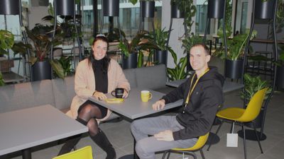 Powercloud-Mitarbeiter Sophia Merkel (links) und Matthias Neu im Firmencafé, vorwiegend in den CI-Farben Schwarz und Gelb gehalten. 