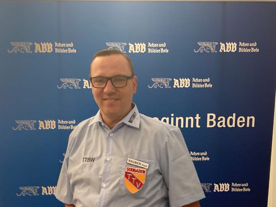 Klaus Rauber steht vor der blauen Werbefläche des ABB.