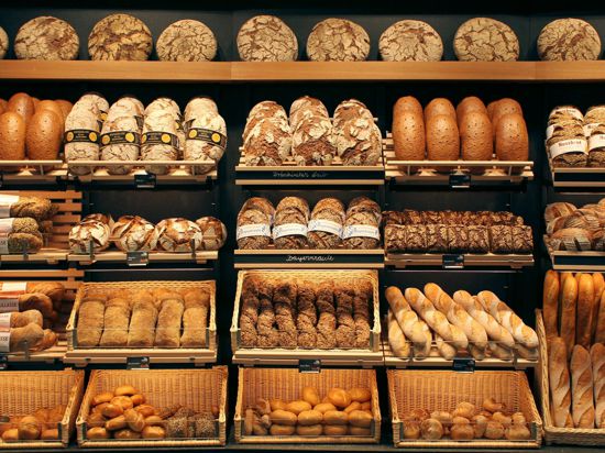 Brote verschiedenster Sorten liegen in Körben und auf Regalen.