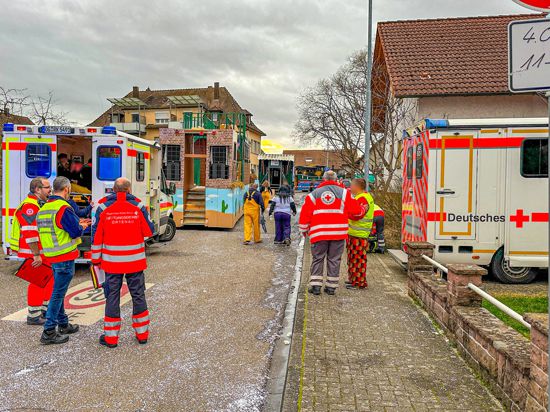 Rettungswagen, Fastnacher und Einsatzkräfte stehen in der Nähe der Unfallstelle in Kehl.