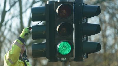 Ein Mann kontrolliert und putzt die Lichter einer Verkehrsampel. Auf Deutschlands Straßen sorgt die klassische Lichtsignalanlage in Rot-Gelb-Grün schon seit Jahrzehnten für Struktur und Ordnung: Je nach Auslegung ist es inzwischen sogar schon ein ganzes Jahrhundert. (zu dpa-Korr "Drei Lichter gegen das Chaos") +++ dpa-Bildfunk +++