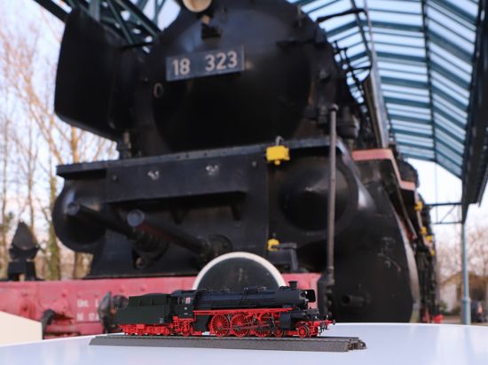 Dampflok 18 323 als Modell mit dem Original im Hintergrund 
