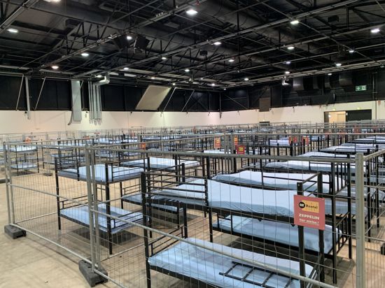 Notunterkunft: In Messehalle 2 werden die ab Montag erwarteten Asylbewerber mit Essen versorgt, nebenan in Halle 1 wurden Betten für bis zu 400 Menschen aufgebaut.